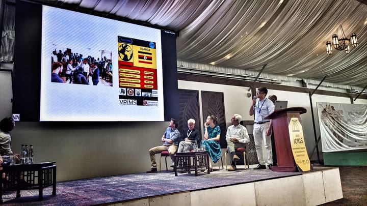 A speaker at the lectern beside a seated congress panel