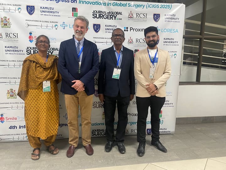 Four participants together beside the congress backdrop
