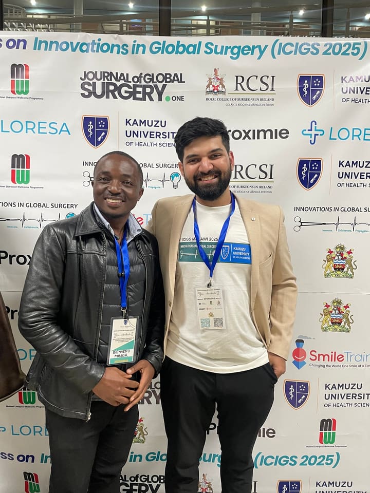 Two participants posing beside the congress backdrop